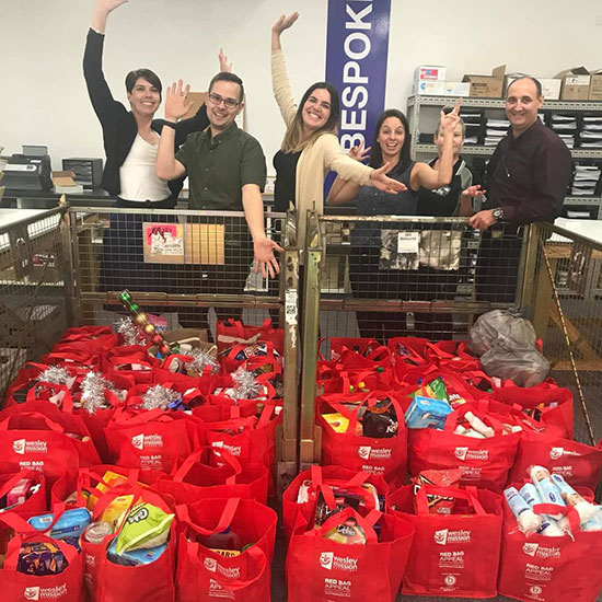 team standing above charity mail packs